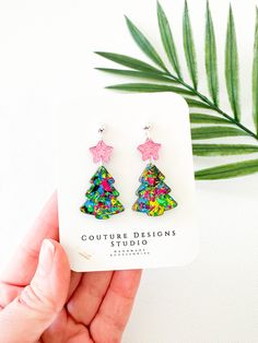 These bright glitter Christmas Tree Earrings are lightweight and such a fun way to celebrate the holiday season! They are made using acrylics that include hot pink mirrored stars and green multi colored flake glitter trees. The total length of these earrings measure 1.85 inches long and .9 inches wide. They are set using your choice of Stainless Steel Gold or Silver ball posts with clear silicone backings OR lead free and nickel free ear wires (suitable for even sensitive ears) in either a Silver, Gold, Gunmetal or Antique Gold finish. Each pair of earrings come shipped attached to an earring card and sealed in their own clear packaging. All earrings purchased from my shop ship in a box so they arrive safely to you. Glowforge Earrings Christmas, Resin Christmas Earrings, Christmas Tree Earrings Clay, Christmas Tree Faux Leather Earrings, Acrylic Tree Earrings, Glitter Christmas Tree, Tree Earrings, Laser Cut Jewelry, Holiday Earrings