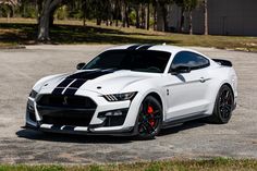 a white sports car parked in a parking lot