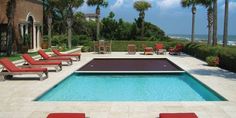 an empty swimming pool with lounge chairs around it