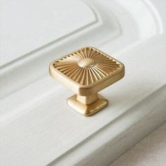 a close up of a door handle on a white door with gold trimmings