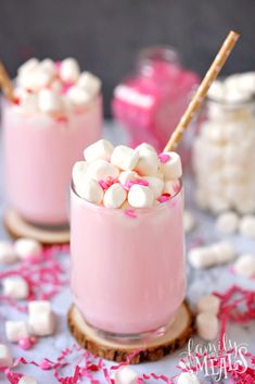 two glasses filled with marshmallows on top of a table