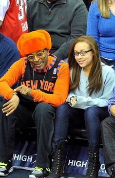 two people sitting next to each other at a basketball game