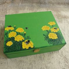 a green box with yellow flowers painted on it