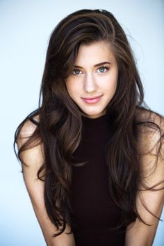 a woman with long hair posing for the camera