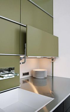 a modern kitchen with green cabinets and white counter tops is seen in this image from the front view