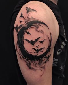 a man's arm with bats flying around it and the moon in the middle