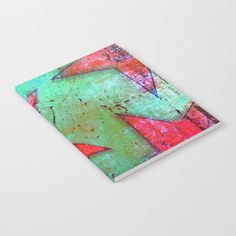 a notebook with an abstract painting on the front and back cover in pink, green, red, and blue