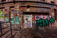 graffiti on the side of a building with stairs leading up to it and an open door