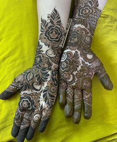 two hands with henna tattoos on them