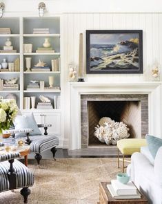 a living room filled with furniture and a fire place under a painting on the wall