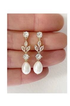 a pair of earrings with white pearls and cubicles on the bottom of each ear