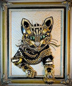 a painting of a cat with green eyes on it's face and gold accents