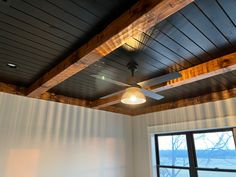 a ceiling fan is hanging from the ceiling in a room with white walls and wood paneling