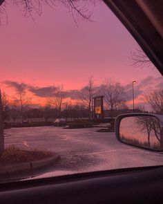 the sun is setting over a parking lot