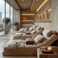 a long row of couches in a room with candles on the wall and windows