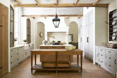 a large kitchen with an island in the center and lots of cupboards on both sides