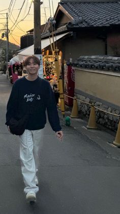 a man walking down the street in front of shops