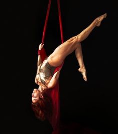 a woman is doing aerial acrobatics on a rope