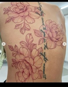 the back of a woman's shoulder with pink flowers on it and chinese writing