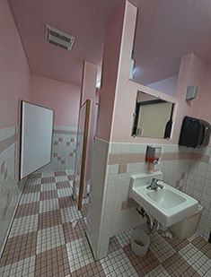 a bathroom with pink walls and tiled flooring is shown in this image, there are mirrors on the wall above the sink