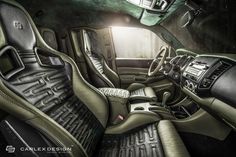 the interior of a car with black leather and green trims, including steering wheel