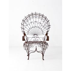 a wrought iron bench with an intricate design on it's back and seat, against a white background