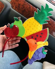 a person is holding up a fruit headband