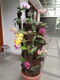 there are many flowers that are in the planter on the sidewalk and it looks like they have been made out of logs