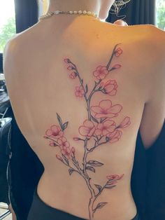 the back of a woman's body with pink flowers on her left shoulder and chest