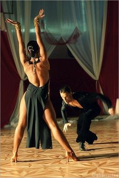 two people are dancing on the dance floor with their hands in the air and one person is wearing a black mask