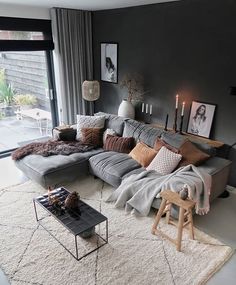 a living room filled with lots of furniture next to a large glass window and a fire place