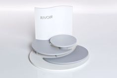 a white table with three plates on it and a sign that says rivoir