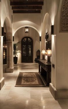 a large hallway with two lamps on either side of the door and a rug on the floor