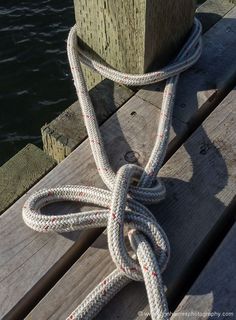 a rope tied to a wooden dock next to the water