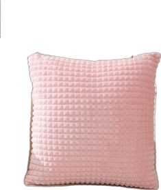 a pink pillow sitting on top of a white wall