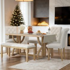 a dining room table and chairs with a christmas tree in the background