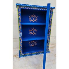 a blue book shelf with ornate designs painted on it