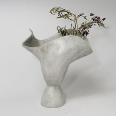 a white vase with some flowers in it