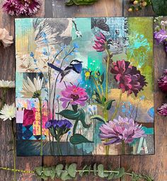 an art work with flowers and leaves on a wooden surface