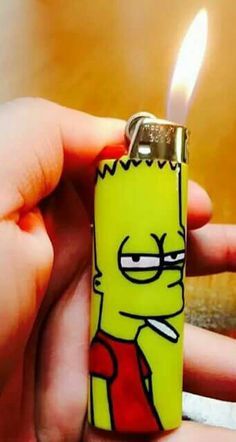 a person holding a lighter in their hand with a cartoon character on the lighter cover