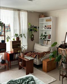 a living room filled with furniture and lots of plants on top of it's shelves