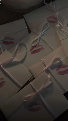 several envelopes tied together with white ribbon and pink lipstick prints on the inside of them