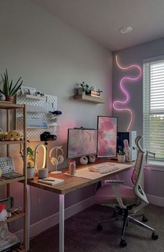 a desk with two computer monitors on top of it next to a shelf filled with books