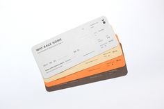 three credit cards sitting next to each other on top of a white surface with an orange stripe