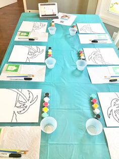 the table is set up with paper and markers to draw faces on it, along with other art supplies