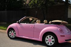 a pink convertible car parked in front of a house