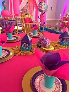 the table is set with pink and blue decorations