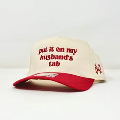 MHC Put it on my Husband's Tab Hats With Sayings, Put It On My Husbands Tab Hat, Trendy Snapback Hat For Sports Events, Trendy Adjustable Snapback Hat For Sports Events, Red Adjustable Snapback Hat With Letter Print, Cool Trucker Hats, Adjustable Snapback Hat With Letter Print For Baseball Season, Sports Events Snapback Hat With Letter Print, Adjustable Trucker Hat With Letter Print For Streetwear