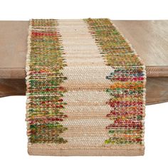 the table runner is made out of jute and has colorful beads on it, along with a wooden bench