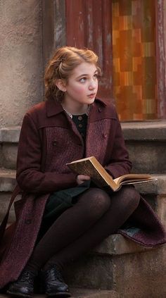 a woman sitting on steps reading a book